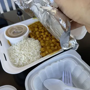 a person holding a foil wrap over a container of food
