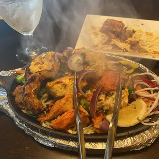 Mixed grill: salmon, shrimp, lamb, chicken, vegetables, lemon