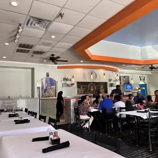 a restaurant with tables and people eating