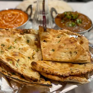 Garlic Naan (left) and Paneer Chili Naan (right); Butter Chicken and Goat Curry in the back
