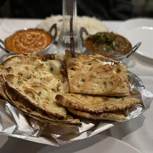 Garlic Naan (left) and Paneer Chili Naan (right); Butter Chicken and Goat Curry in the back