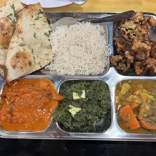 Lunch special - butter chicken, vegetable pakora, curried vegetables, palak paneer, naan, and rice