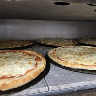 pizzas cooking in an oven