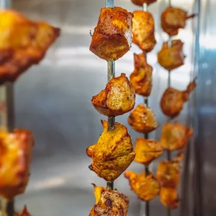 Fresh kebobs being pulled out of tandoor