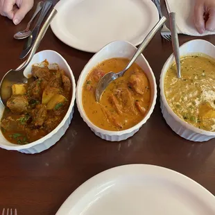 three bowls of curry on a table