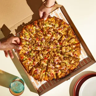 a person grabbing a slice of pizza