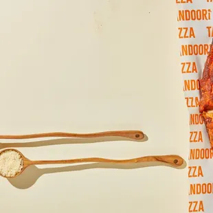 a pizza and a wooden spoon