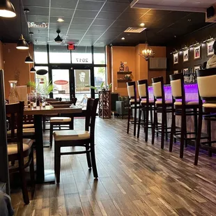 a dining area with a bar and chairs