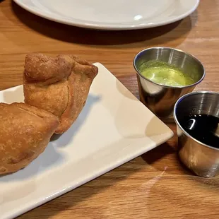 Lamb samosas with coriander and tamarind chutneys.