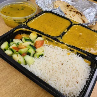 Shahi Paneer lunch with cucumber salad, rice, yellow daal, and naan.