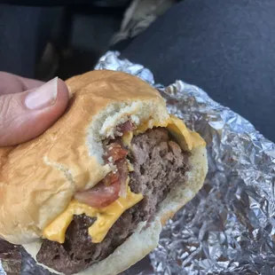 a hand holding a hamburger