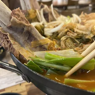a pan of food with chopsticks