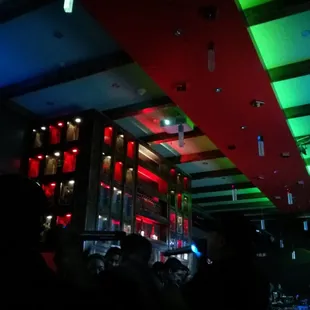 a neon lit bar with people in the foreground