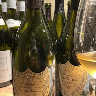 three bottles of wine and a glass of wine