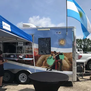 a food truck with a blue and white banner