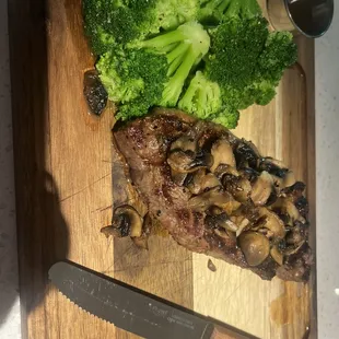 a steak and broccoli on a cutting board