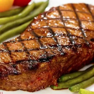 a steak with green beans and tomatoes