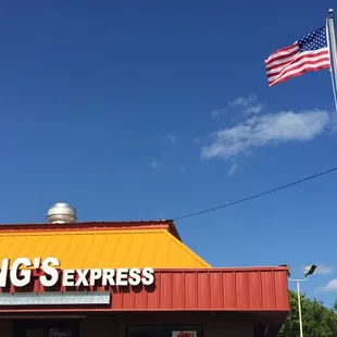 an american flag flying in front of a restaurant