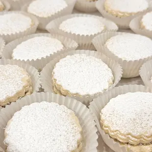 Alfajores: melt in your mouth shortbread cookies sandwich a layer of dulce de leche, rolled on coconut flakes