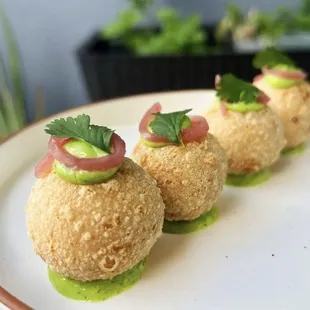 three appetizers on a white plate