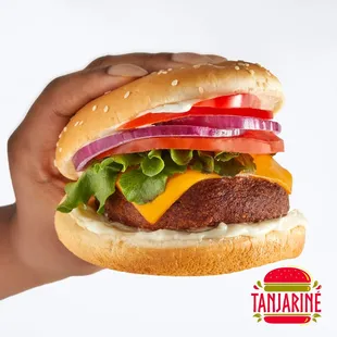 a hand holding a cheeseburger