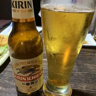 a glass of beer next to a bottle of beer