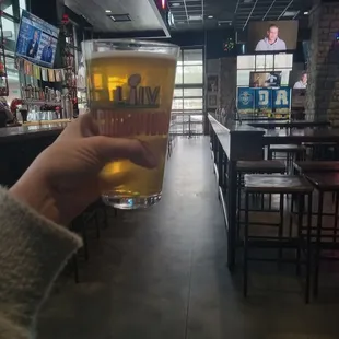 a hand holding a pint of beer