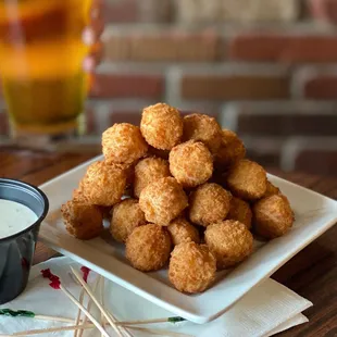 a plate of fried tater tots with dipping sauce