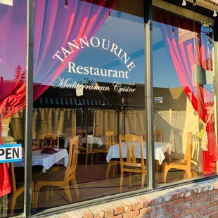 a restaurant window with red curtains
