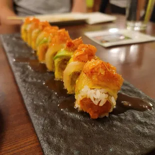 a close up of a sushi roll on a black plate