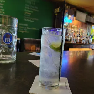 a tall glass with ice and a lime slice