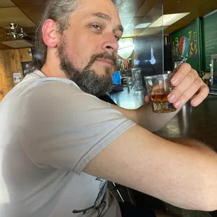 a man sitting at a bar with a drink in his hand