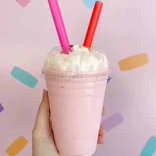 a hand holding a cup of milkshake