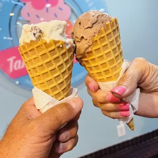 two hands holding ice cream cones