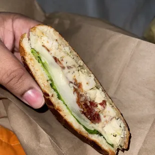 a hand holding a sandwich