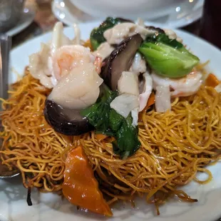 a plate of noodles with shrimp and vegetables