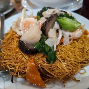 a plate of noodles with shrimp and vegetables