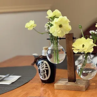 two vases with flowers on a table