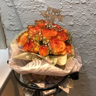 a bouquet of orange roses and baby&apos;s breath