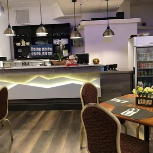 a dining area with a bar and chairs