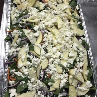 a salad with apples, onions, and feta cheese