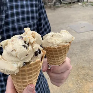 a man holding two ice cream cones