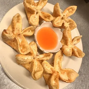 a plate of dumplings with a dipping sauce