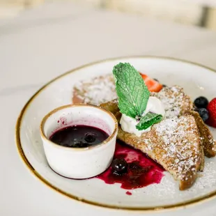 a plate of food with powdered sugar and berries