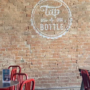 a brick wall and red chairs