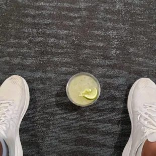 a person standing next to a glass of lemonade