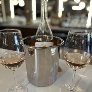 three glasses of wine and a bottle of wine