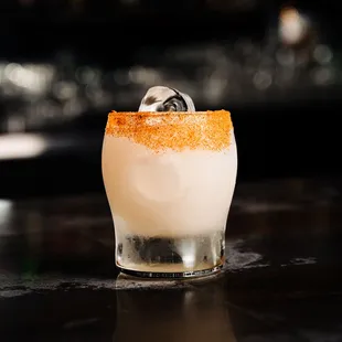 a cocktail with orange garnish