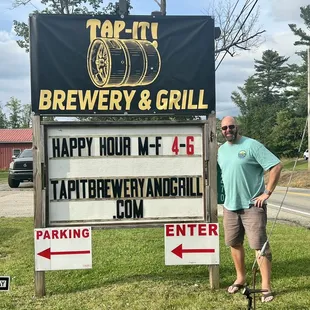 a man standing in front of a sign