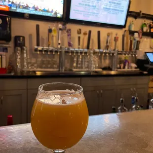 a glass of beer on a bar